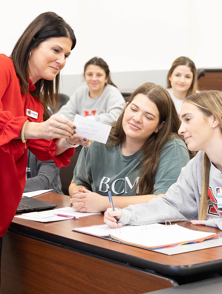 Nursing professor Dr Alaina Daigle assisting Nicholls State University nursing students in class